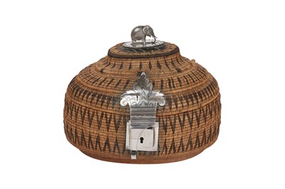 Lot 253 - A SINHALESE SILVER-MOUNTED LIDDED RATTAN BASKET WITH ELEPHANT FINIAL