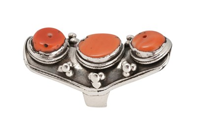 Lot 126 - A TIBETAN KHAMPA CORAL-SET MALE 'SADDLE' SILVER RING