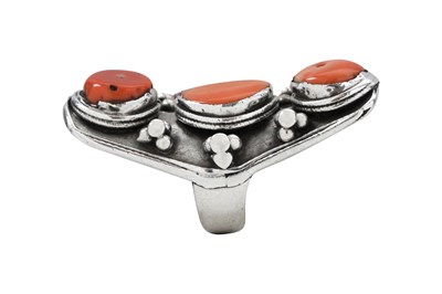 Lot 126 - A TIBETAN KHAMPA CORAL-SET MALE 'SADDLE' SILVER RING