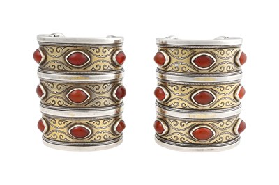 Lot 95 - A PAIR OF TURKMEN TEKKE TRIBE CARNELIAN-SET PARCEL-GILT SILVER CUFF BRACELETS (BILEZIK)