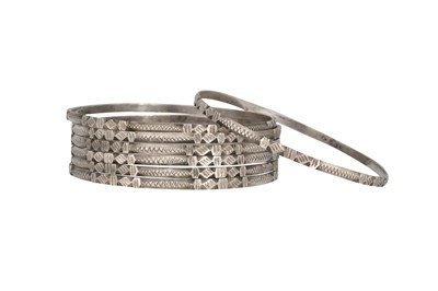 Lot 24 - SEVEN INCISED SILVER BANGLES WITH GEOMETRIC MOTIFS