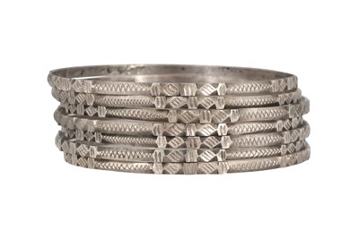 Lot 24 - SEVEN INCISED SILVER BANGLES WITH GEOMETRIC MOTIFS