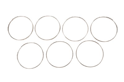 Lot 24 - SEVEN INCISED SILVER BANGLES WITH GEOMETRIC MOTIFS