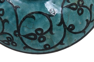 Lot 258 - A BLACK-PAINTED TURQUOISE-GLAZED SELJUK KASHAN-REVIVAL POTTERY DISH WITH COURTLY COUPLE