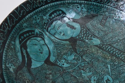 Lot 258 - A BLACK-PAINTED TURQUOISE-GLAZED SELJUK KASHAN-REVIVAL POTTERY DISH WITH COURTLY COUPLE