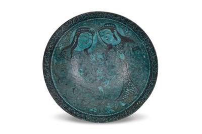 Lot 161 - A KASHAN-REVIVAL BLACK-PAINTED TURQUOISE-GLAZED POTTERY DISH WITH COURTLY COUPLE