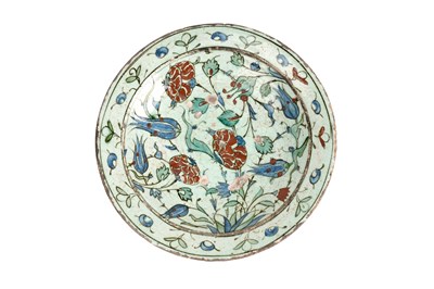 Lot 137 - AN IZNIK POTTERY DISH WITH RED-SPECKLED BLUE TULIPS