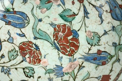 Lot 137 - AN IZNIK POTTERY DISH WITH RED-SPECKLED BLUE TULIPS