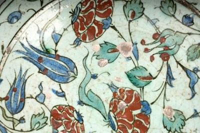 Lot 137 - AN IZNIK POTTERY DISH WITH RED-SPECKLED BLUE TULIPS