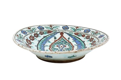 Lot 133 - AN IZNIK POTTERY DISH WITH ARABESQUE, SAZ LEAVES, AND FLORAL DECORATION