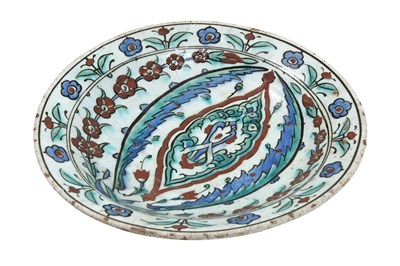 Lot 133 - AN IZNIK POTTERY DISH WITH ARABESQUE, SAZ LEAVES, AND FLORAL DECORATION