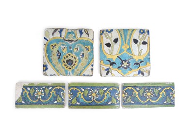 Lot 153 - FIVE CUERDA SECA POTTERY TILES WITH FLOWERS AND ARABESQUE