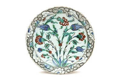 Lot 173 - A LARGE IZNIK POTTERY DISH WITH RED CARNATIONS AND BLUE TULIPS